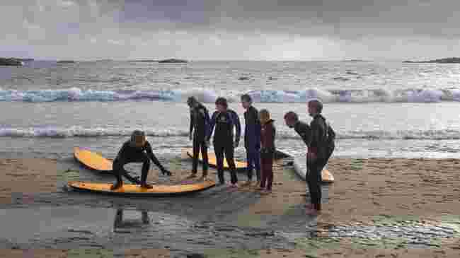 Surfelærer instruerer på stranda.