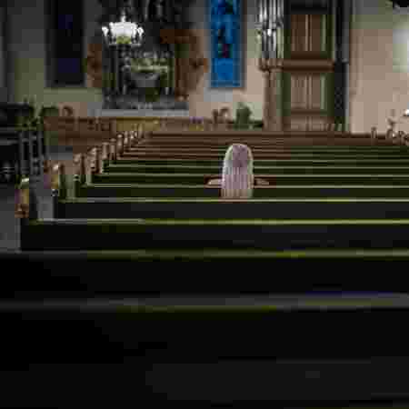 Jente sitter alene i kirkebenk